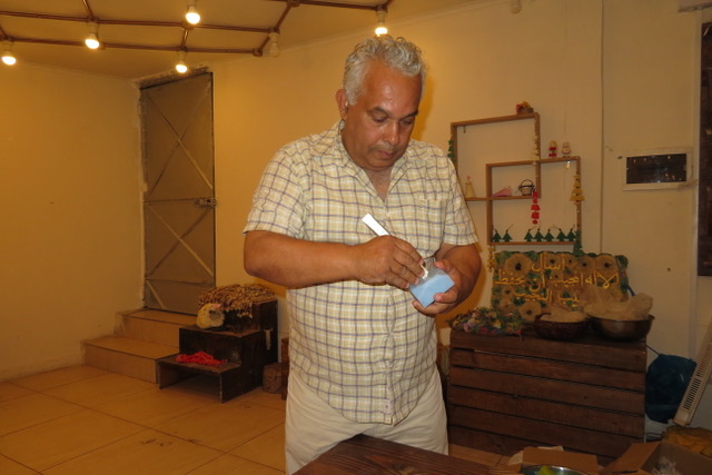 Bader Hassoun starts shaping a rectangular block of soap