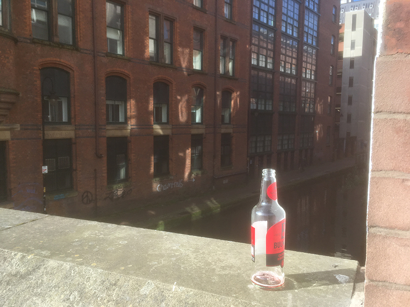 Early morning Manchester. Empty bottle at the front, graffiti at the back.