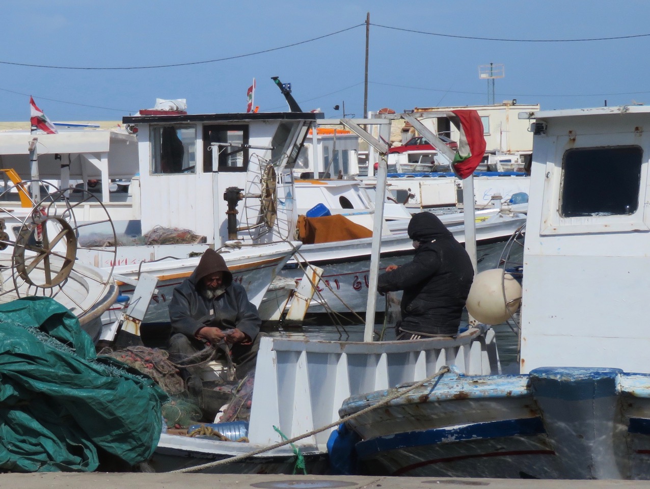 Fishermen repair their nets in El Mina harbour